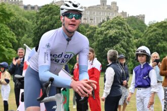 A man on a bicycle in front of Windsor Castle.
