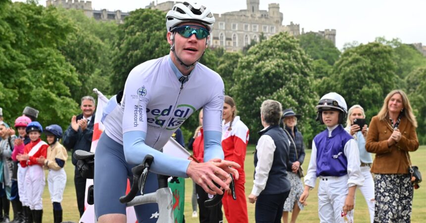 A man on a bicycle in front of Windsor Castle.