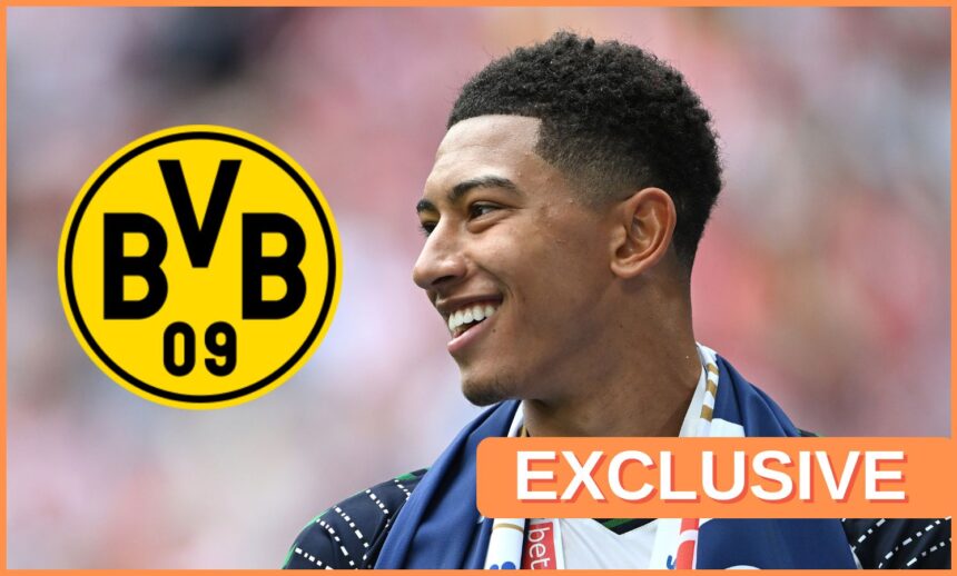 Jobe Bellingham smiles at Dortmund club crest.