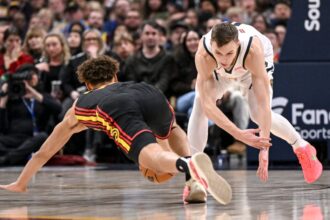 Christian Braun (0) of the Denver Nuggets and Dyson Daniels (5) of the Atlanta Hawks compete for a loose ball at Ball Arena during the second quarter.
