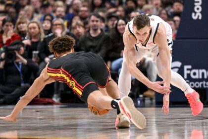 Christian Braun (0) of the Denver Nuggets and Dyson Daniels (5) of the Atlanta Hawks compete for a loose ball at Ball Arena during the second quarter.