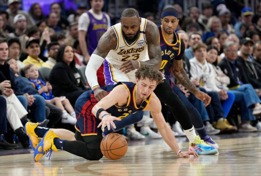 Golden State Warriors player Brandin Podzemski looks for a loose ball alongside Gary Payton II during a game against LeBron James.