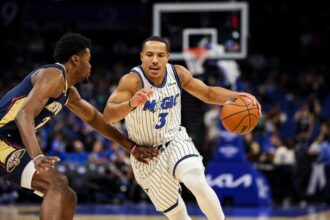 Desmond Bane #3 of the Orlando Magic dribbles the ball against Herbert Jones #2 of the New Orleans Pelicans during the first half of a preseason game.