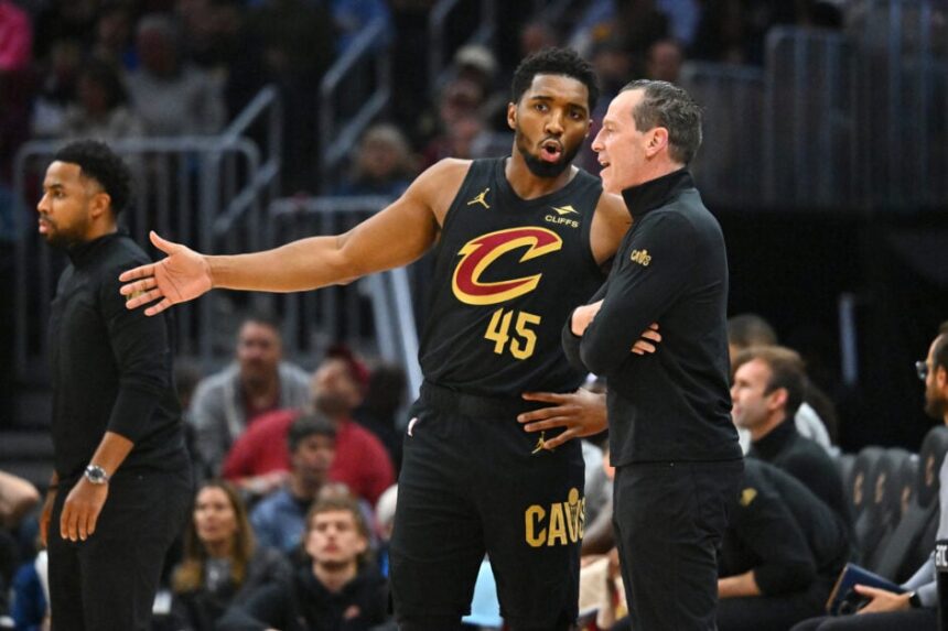 Cleveland Cavaliers head coach Kenny Atkinson and Donovan Mitchell #45 watch the second half of a game against the Philadelphia 76ers at Rocket Mortgage Fieldhouse on December 21, 2024 in Cleveland, Ohio.