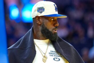 LeBron James courtside wearing a white baseball cap