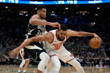 Karl-Anthony Towns #32 of the New York Knicks dribbles the ball against #34 Giannis Antetokounmpo of the Milwaukee Bucks during the third quarter at Fiserv Forum.