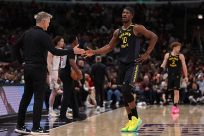 Golden State Warriors head coach Steve Kerr high-fives Jimmy Butler #10 during the second half of the game against the Chicago Bulls at the United Center.