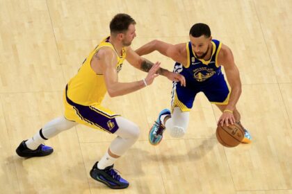 Stephen Curry #30 of the Golden State Warriors dribbles the ball against Luka Doncic #77 of the Los Angeles Lakers.