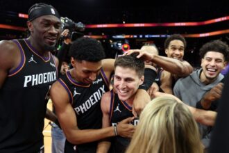 Mark Williams #15, Ryan Dunn #0, and Collin Gillespie #12 of the Phoenix Suns celebrate after defeating the Minnesota Timberwolves 114-113 in an NBA Cup game at Mortgage Matchup Center.