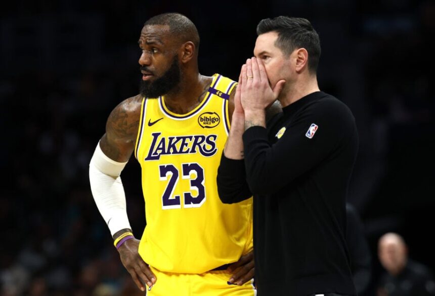 Los Angeles Lakers head coach JJ Redick and #23 LeBron James speak during the first half of the game against the Charlotte Hornets at Spectrum Center.