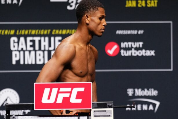 Cameron Smotherman poses on the scale at the UFC 324 official weigh-in