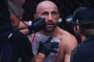 Alexander Volkanovski consults with his team in between rounds at UFC 325