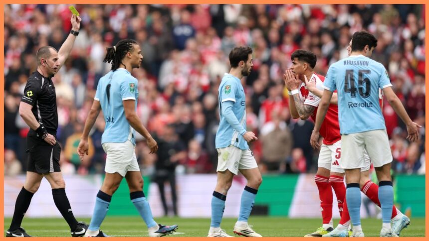 Referee Peter Bankes shows a yellow card to Piero Hincapie of Arsenal during the Carabao Cup Final match Arsenal and between Manchester City at Wembley Stadium
