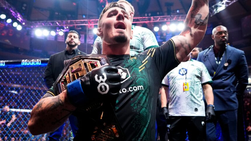 Tom Aspinall celebrates after winning the UFC interim heavyweight title at UFC 295
