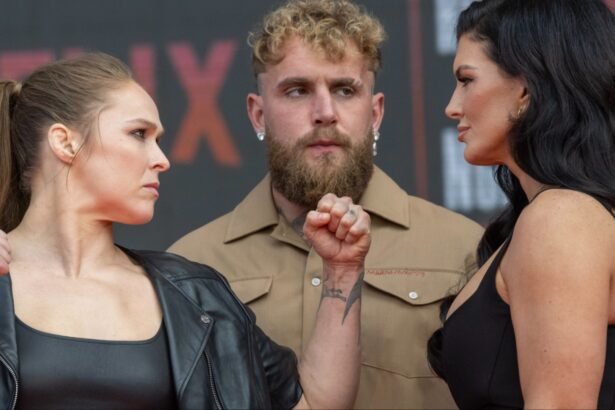 Ronda Rousey and Gina Carano facing off in front of Jake Paul